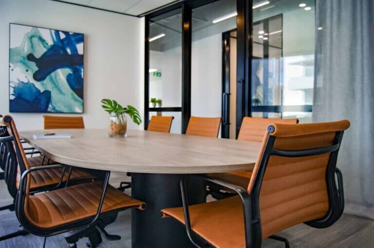 A conference room at a staffing agency with 8 leather chairs around a desk