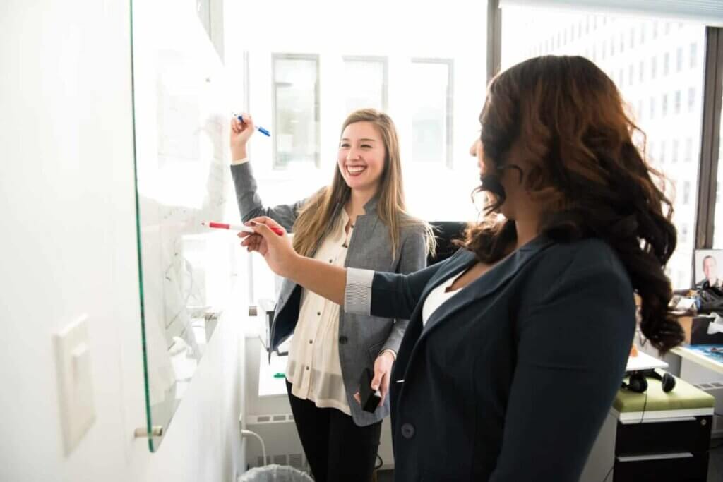 2 talent acquisition specialists collaborating on a whiteboard